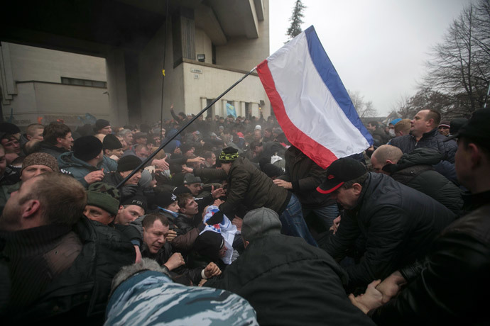 Ukrainian men help pull one another out of a stampede as a flag of Crimea is seen during clashes at rallies held by ethnic Russians and Crimean Tatars near the Crimean parliament building in Simferopol February 26, 2014. (Reuters / Baz Ratner)